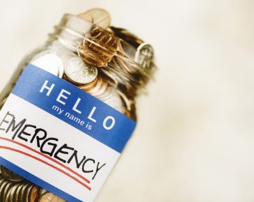 overturned mason jar overfilled with coins with a sticker that reads "hello, my name is emergency"